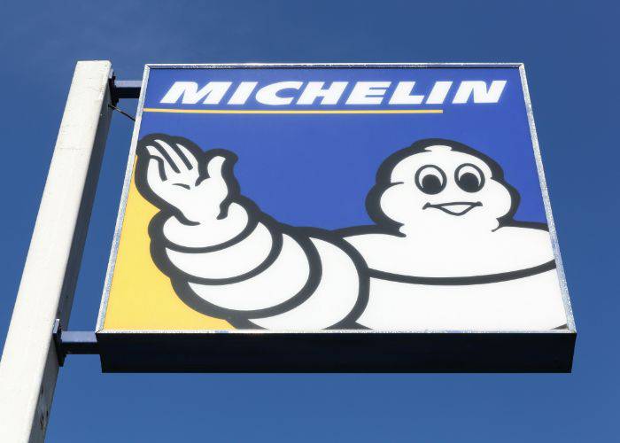 The Michelin Man on a sign, set against a blue sky.